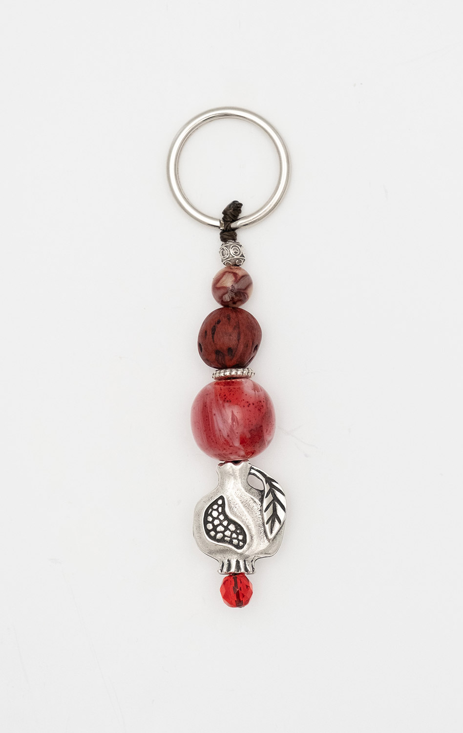 Keyring - amulet  made of artificial resin and conifer seed  with a pomegranate